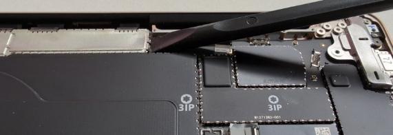 Screenshot that shows using a tool to begin prying up the T3 Shield Lid from the Surface Laptop