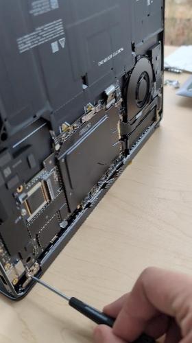 Screenshot that shows using a 6IP driver to remove three screws from the device's left hinge.